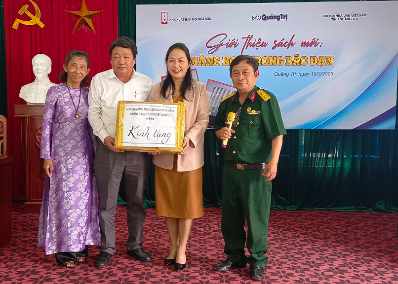 Hai t&aacute;c giả Nguyễn Thị Thu Sương - L&ecirc; Anh Dũng (ngo&agrave;i c&ugrave;ng) v&agrave; Tổng Bi&ecirc;n tập B&aacute;o Quảng Trị Trương Đức Minh Tứ trao tặng &aacute;o d&agrave;i cho Hội LHPN c&aacute;c huyện Gio Linh, Vĩnh Linh